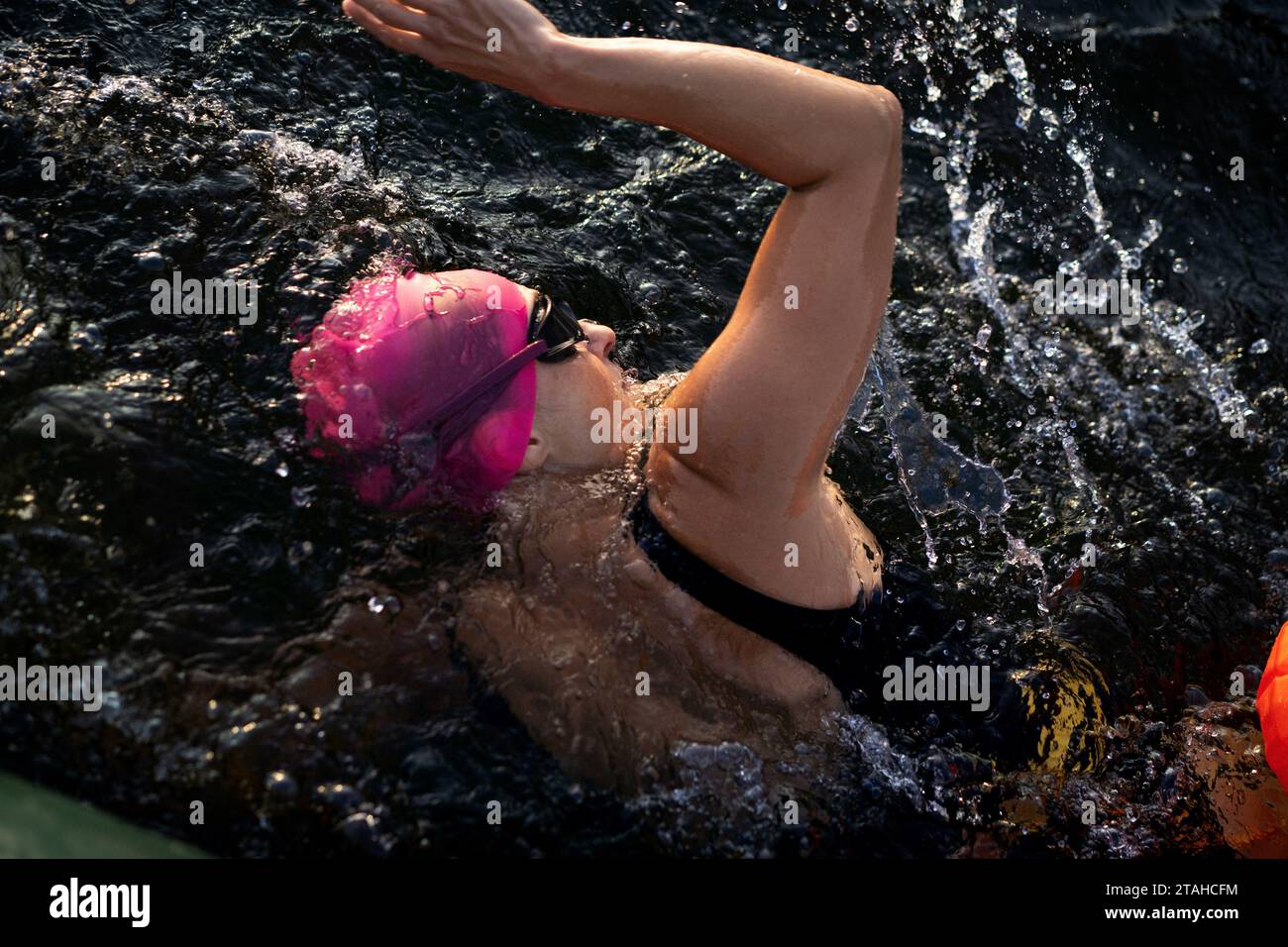 Nuotatore professionista in muta nuota in mare aperto su un lago. Foto Stock