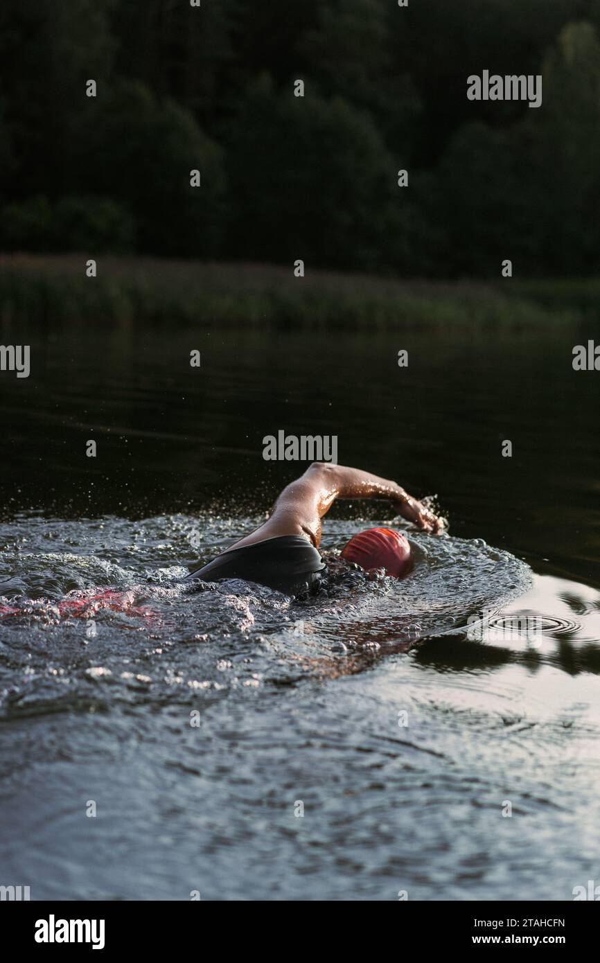 Nuotatore professionista in muta nuota in mare aperto su un lago. Foto Stock