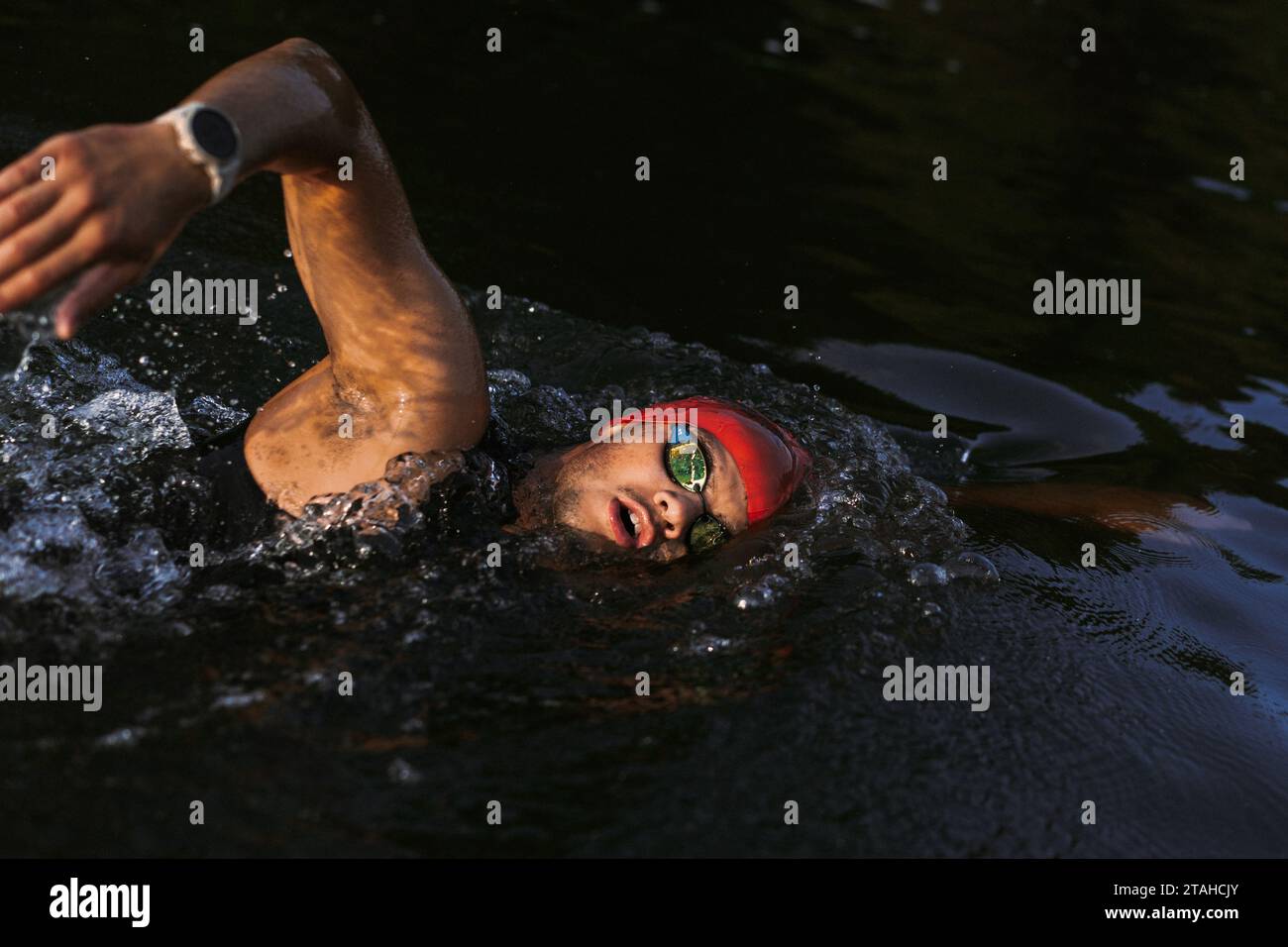 Nuotatore professionista in muta nuota in mare aperto su un lago. Foto Stock