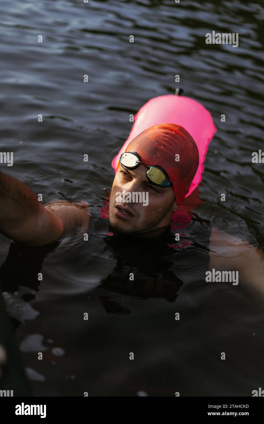 Nuotatore professionista in muta nuota in mare aperto su un lago. Foto Stock