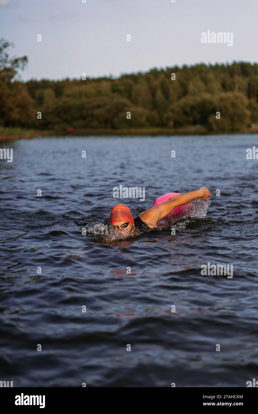 Nuotatore professionista in muta nuota in mare aperto su un lago. Foto Stock