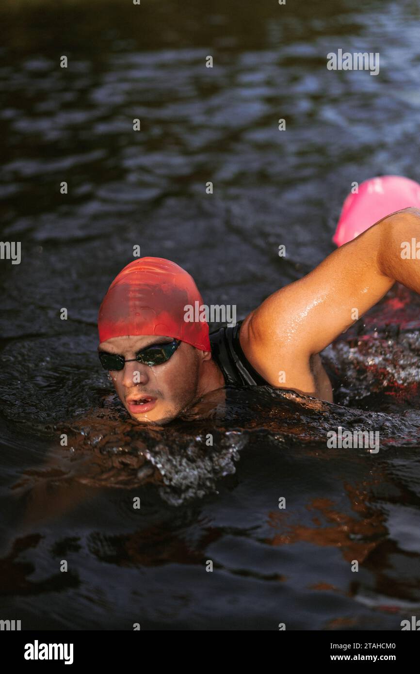 Nuotatore professionista in muta nuota in mare aperto su un lago. Foto Stock