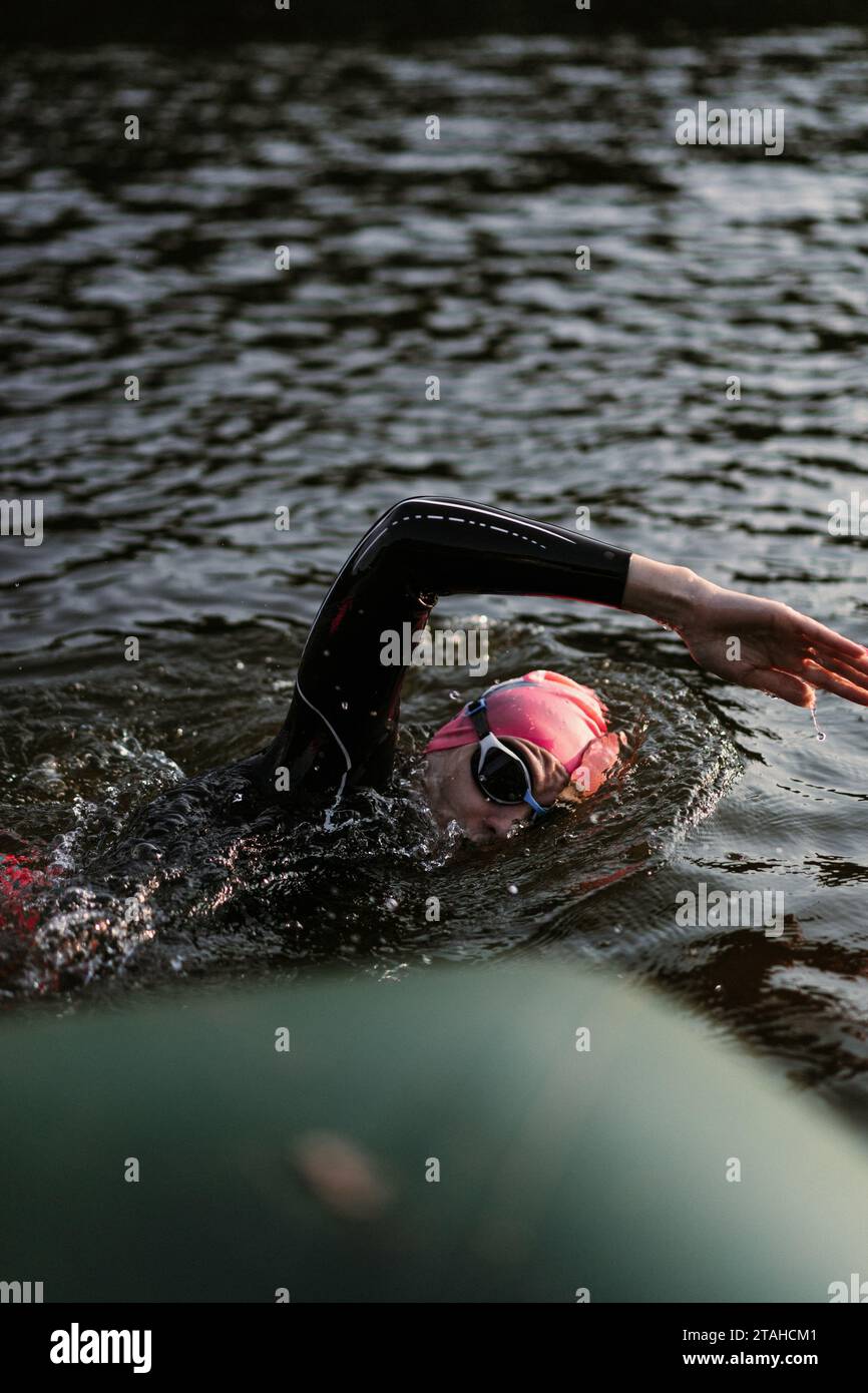 Nuotatore professionista in muta nuota in mare aperto su un lago. Foto Stock
