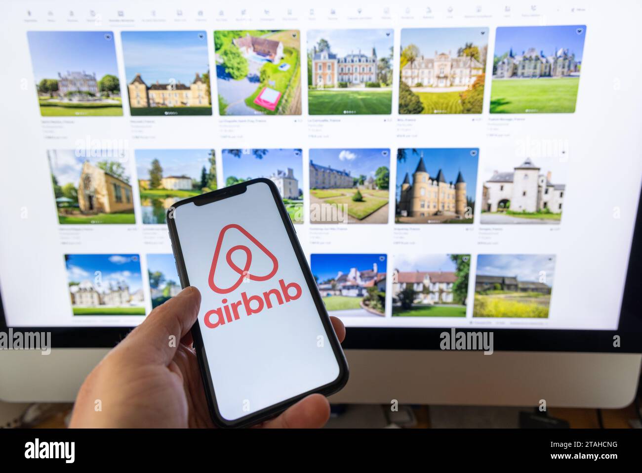 Parigi, Francia - 30 novembre 2023 : smartphone con impugnatura femminile con applicazione Airbnb. Airbnb è un marketplace online e un servizio di ospitalità, Foto Stock