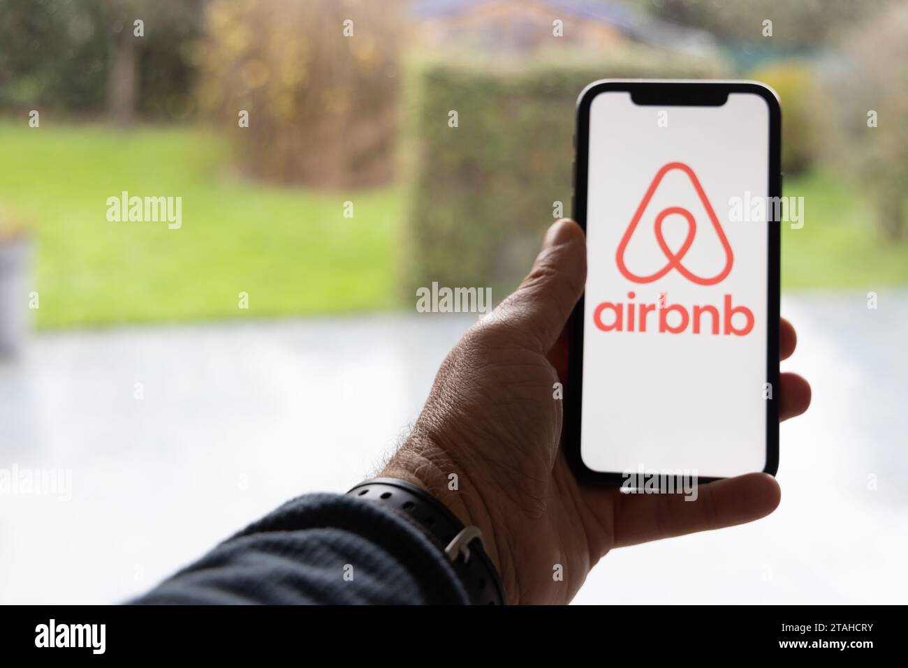 Parigi, Francia - 30 novembre 2023 : smartphone Man Hand Holding con applicazione Airbnb. Airbnb è un marketplace online e un servizio di ospitalità, ena Foto Stock