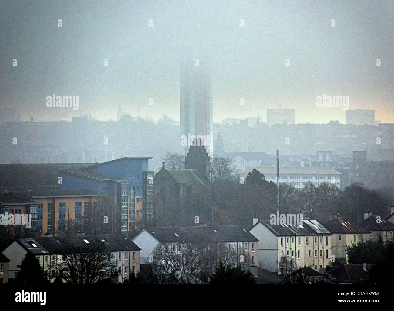 Glasgow, Scozia, Regno Unito. 1 dicembre 2023. Tempo nel Regno Unito: Durante la notte il gelo ha visto una nebbia fredda sulla città e l'edificio più alto della scozia, la torre del tribunale di anniesland, mentre la nebbia riduce la visibilità sui tetti ghiacciati. Credit Gerard Ferry/Alamy Live News Foto Stock