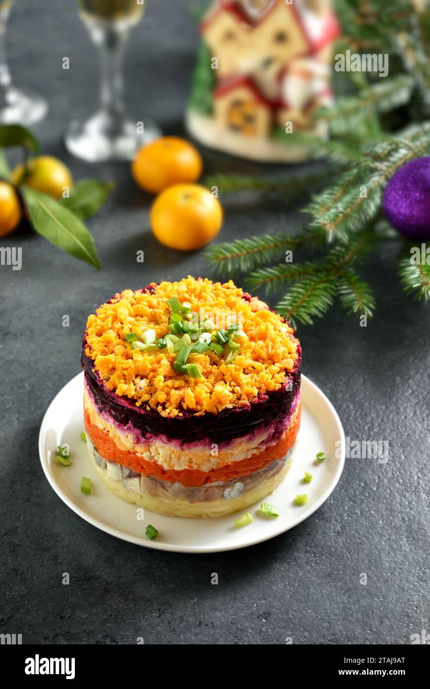 Insalata Shuba. Aringhe vestite, aringhe sotto il cappotto di pelliccia. Insalata di verdure a strati natalizia con aringhe e verdure bollite. Sfondo scuro, primo piano Foto Stock