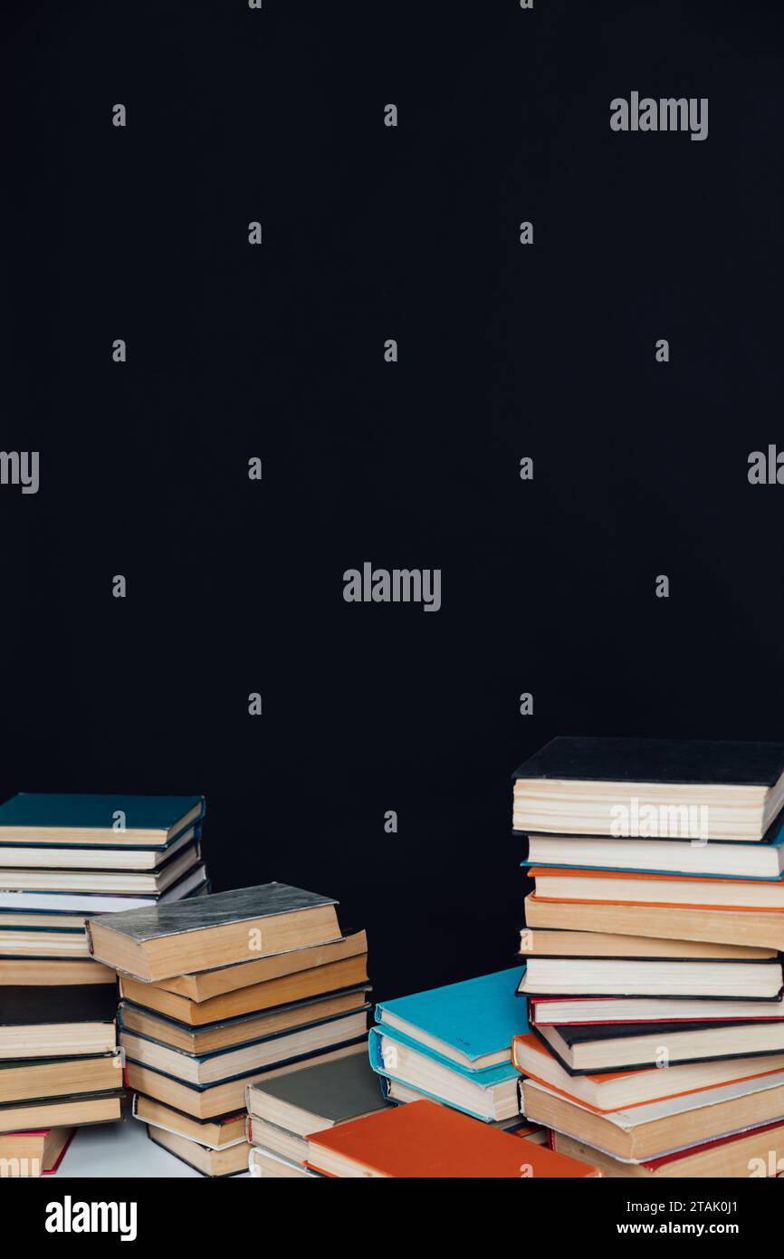 Tantissimi vecchi libri educativi su una libreria a sfondo nero Foto Stock