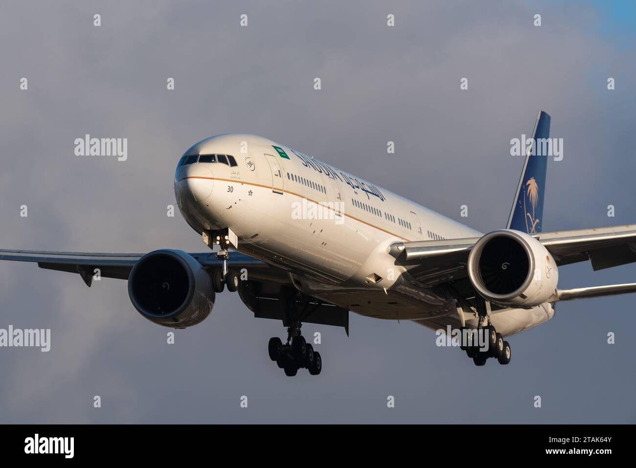 Saudi Arabian Airlines, Saudia, Boeing 777-300ER aereo di linea HZ-AK30 nelle finali per atterrare all'aeroporto di Londra Heathrow, Regno Unito, al sole invernale di tarda giornata Foto Stock