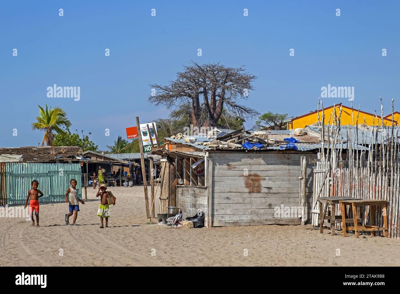 Scena di strada che mostra baracche/case di legno e bambini che giocano nel villaggio costiero di Belo sur Mer, distretto di Morondava, regione di Menabe, Madagascar Foto Stock