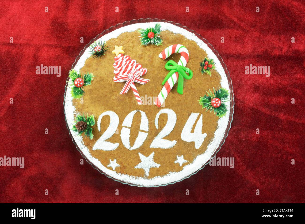 Torta di Capodanno, conosciuta come vasilopita, per il 2024 su tovaglia di velluto rosso Foto Stock