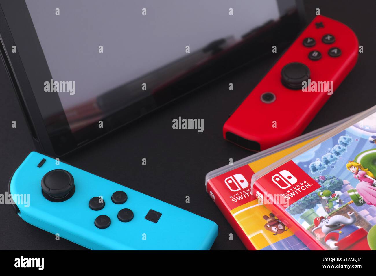 Tambov, Federazione Russa - 01 dicembre 2023 Una console Nintendo Switch con svantaggi distaccati che si trova vicino a una pila di giochi Nintendo Switch in box. Foto Stock