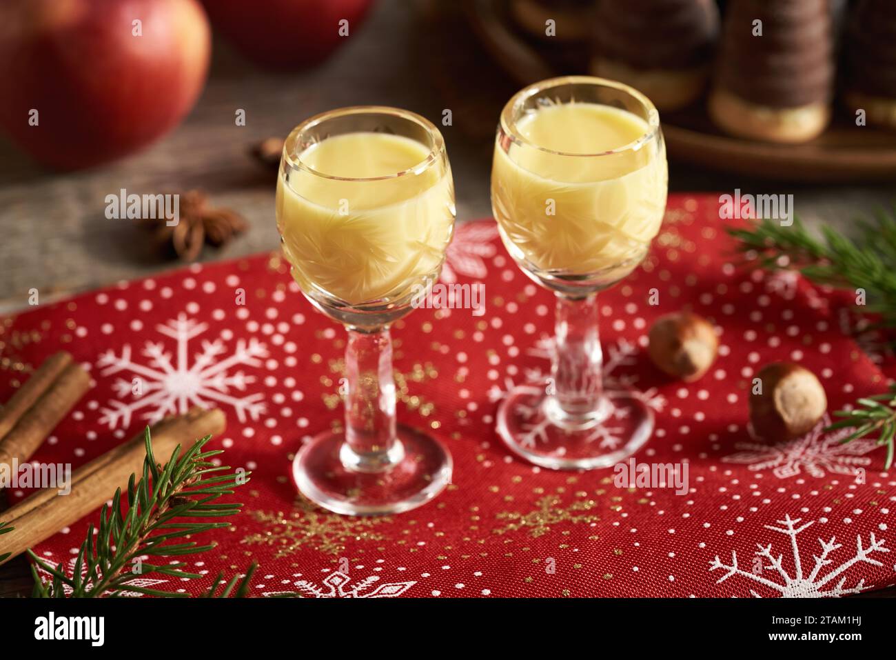 Eggnog in due bicchieri piccoli con mele e biscotti di Natale sullo sfondo Foto Stock