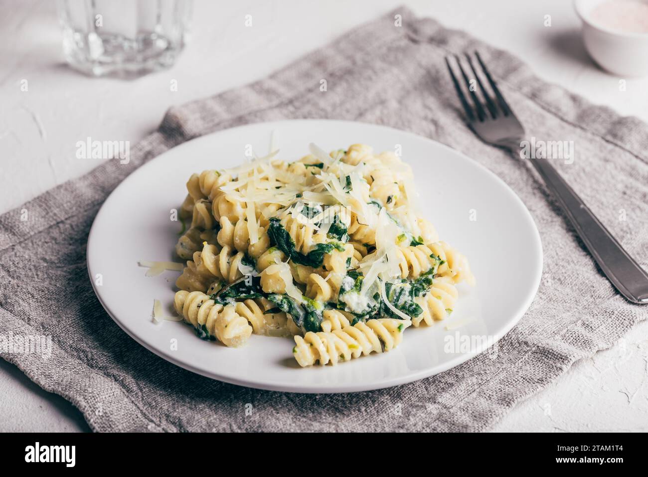 Pasta cremosa di spinaci con ricotta e parmigiano su piatto bianco Foto Stock
