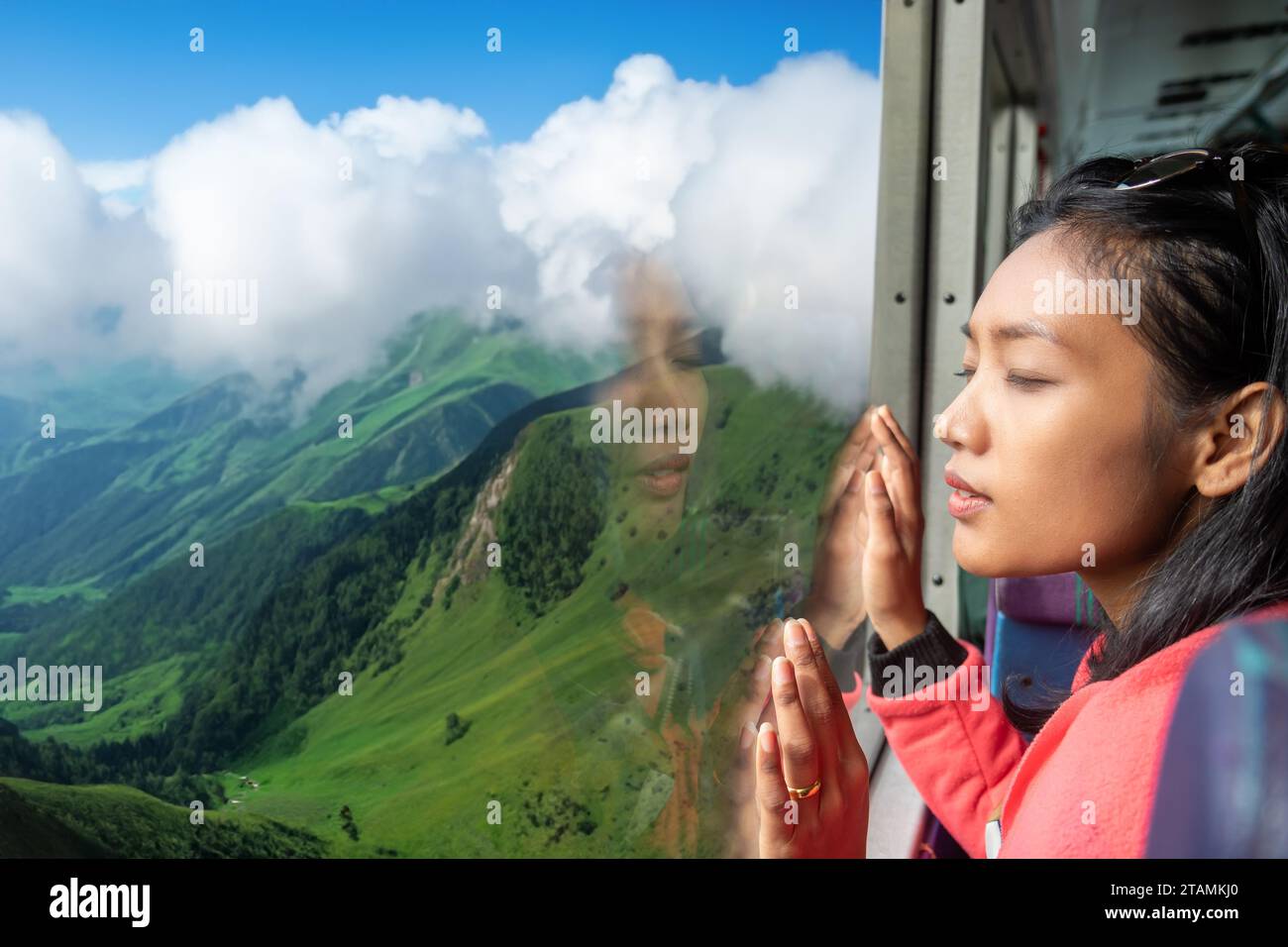 Una giovane donna sta guardando sognando nella valle da un autobus in movimento Foto Stock