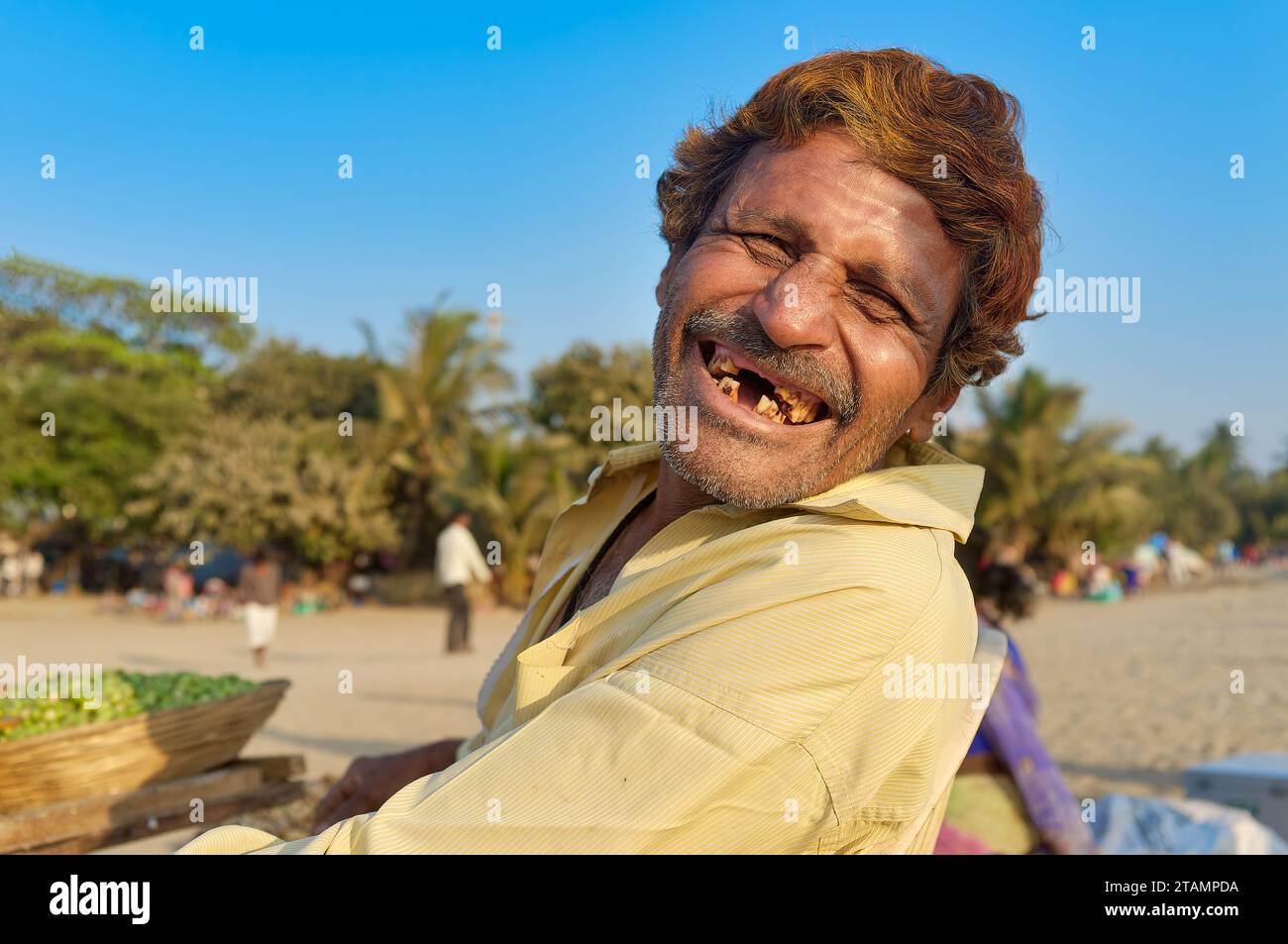 Ritratto di un allegro venditore di cibo a Chowpatty Beach, Mumbai, India, ridendo e sfavillando un sorriso quasi senza denti Foto Stock