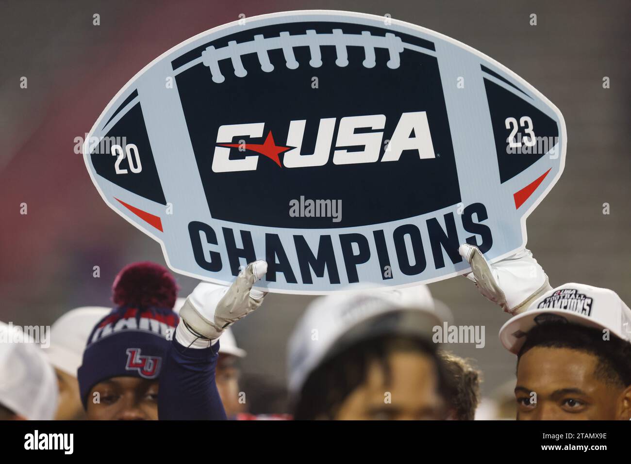 Lynchburg, Virginia, USA. 1 dicembre 2023. Un giocatore di Liberty Flames tiene un'insegna Conference USA Champions 2023 dopo la partita di campionato NCAA Conference USA tra New Mexico State Aggies e Liberty Flames al Williams Stadium di Lynchburg, Virginia. Greg Atkins/CSM (immagine di credito: © Greg Atkins/Cal Sport Media). Credito: csm/Alamy Live News Foto Stock