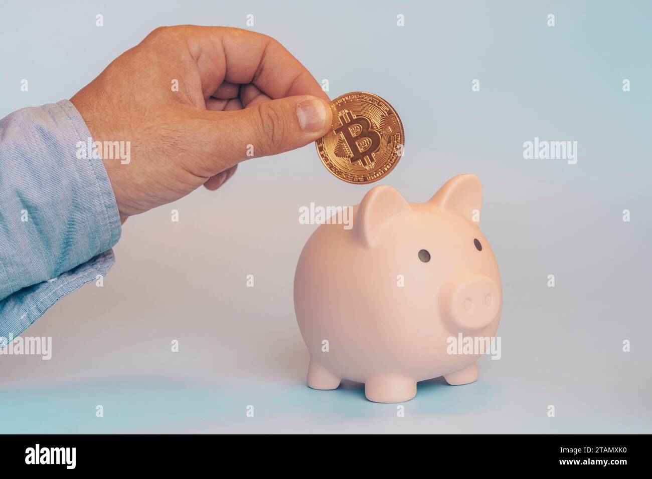 Criptovaluta e concetto di risparmio. Salvadanaio, le mani contengono denaro virtuale bitcoin d'oro. Foto Stock