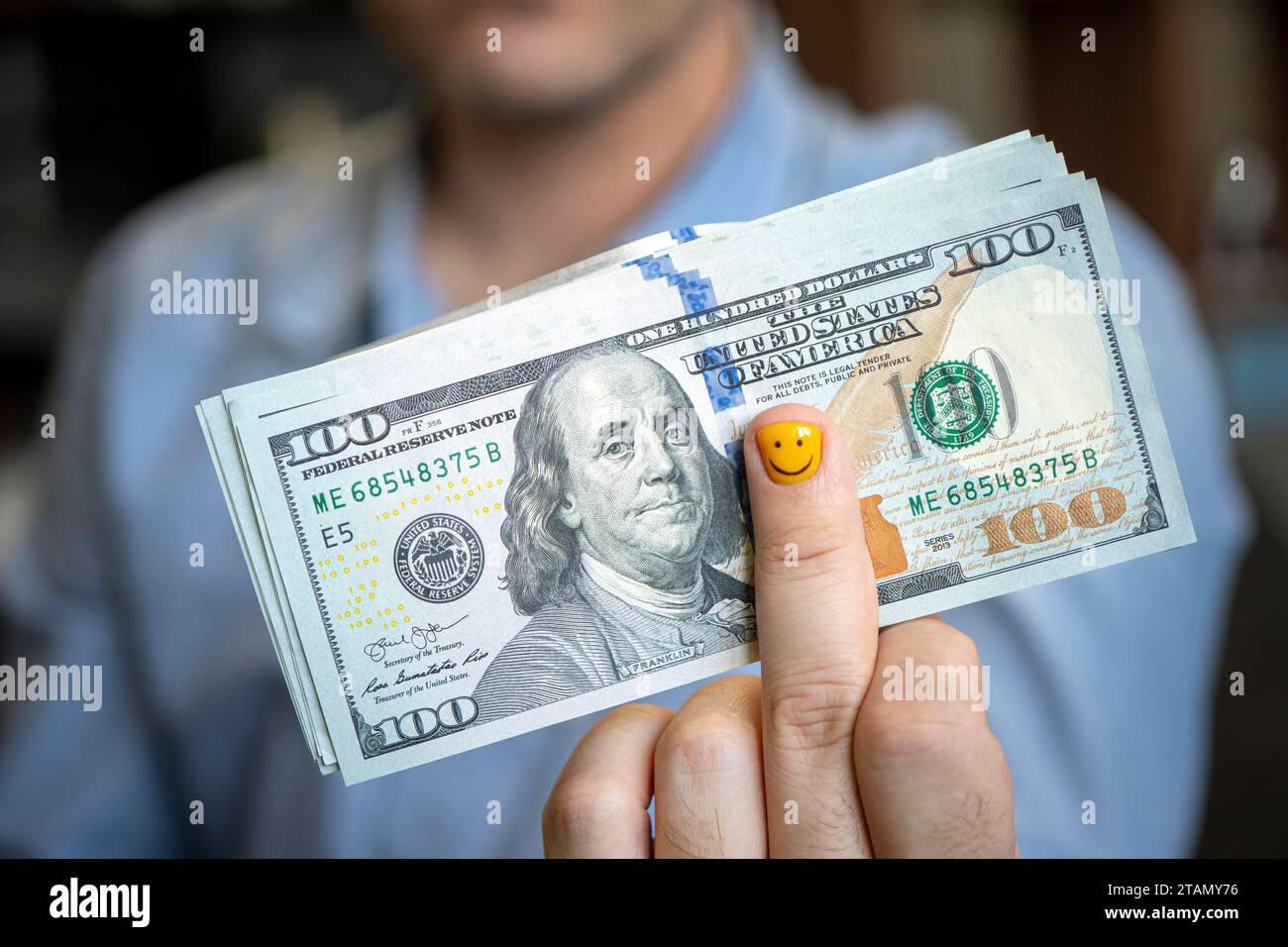 dollari in mano. Uomo d'affari in camicia blu che regge 500 dollari. un fan dei soldi. Manicure per uomini sulla mano. Il concetto della gioia dello stipendio e' Foto Stock