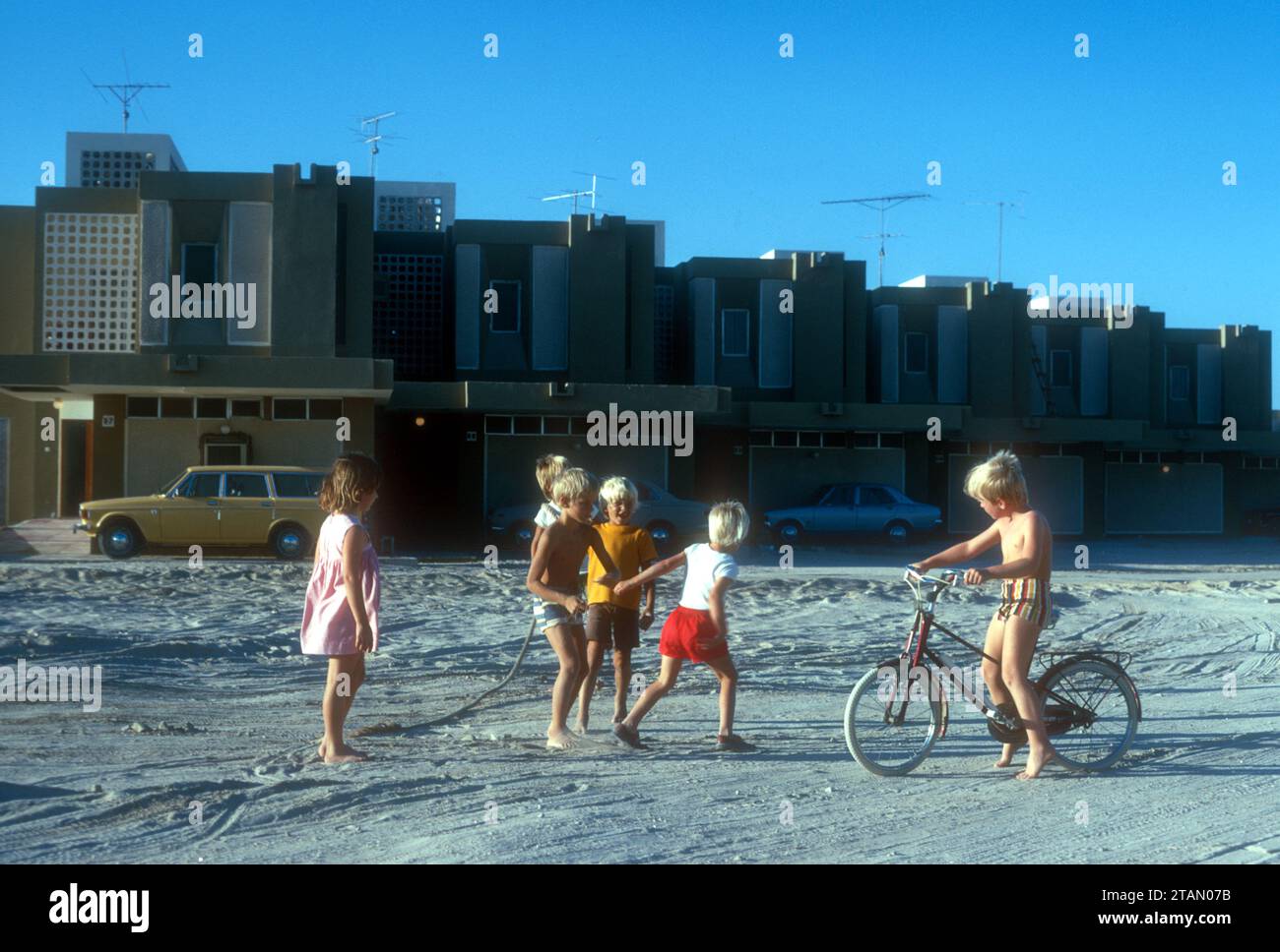 Bambini britannici che giocano all'esterno di nuove case costruite per gli espatriati ad Abu Dhabi, 1975 Foto Stock