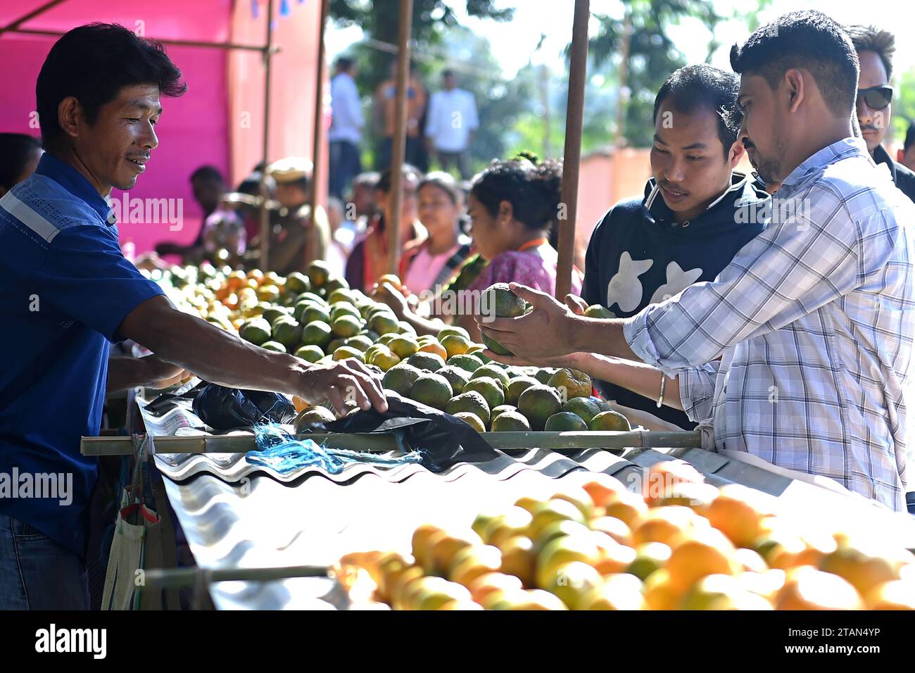 La gente compra arance durante il Festival dell'arancia nel villaggio di Taibaglai (Killa) organizzato dall'Agricoltura e Farmers Welfare di Tripura. Agartala. Tripura, India. Foto Stock