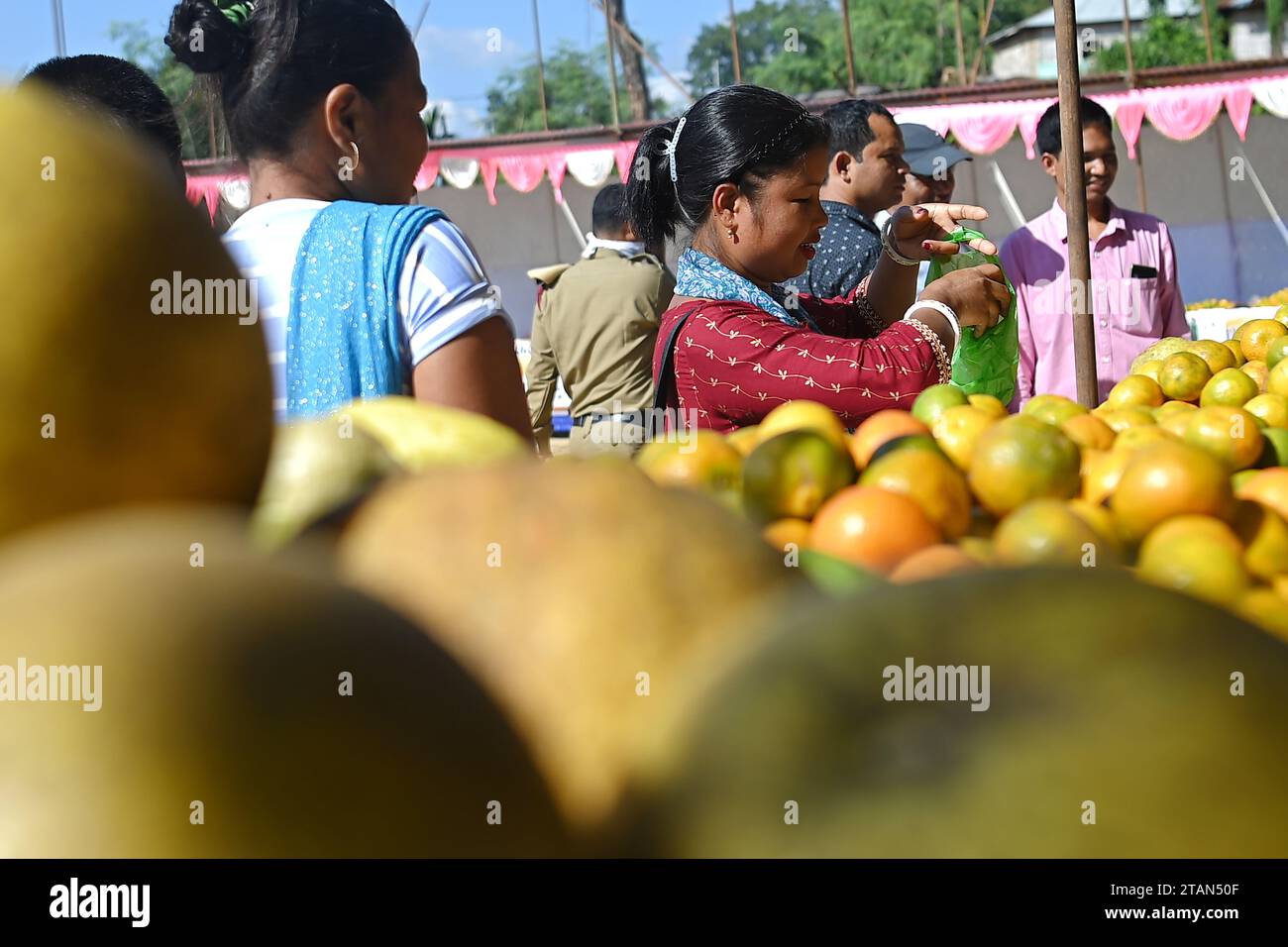 La gente compra arance durante il Festival dell'arancia nel villaggio di Taibaglai (Killa) organizzato dall'Agricoltura e Farmers Welfare di Tripura. Agartala. Tripura, India. Foto Stock