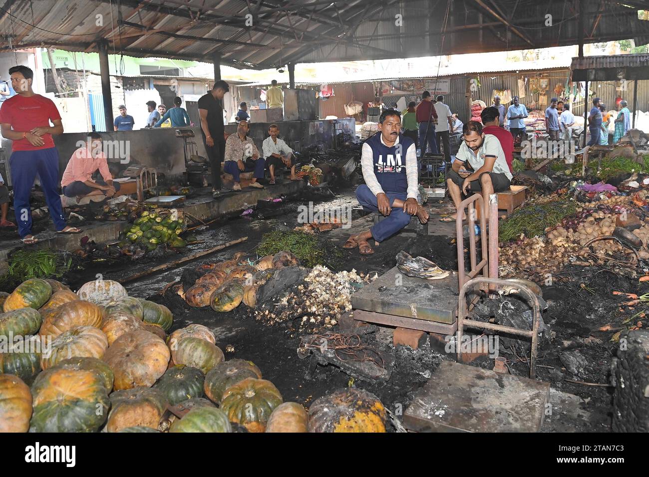 I proprietari di negozi e i venditori sono visti di fronte ai loro negozi bruciati e alle bancarelle di verdure al mercato di Battala, il secondo mercato più grande di Tripura. Un enorme incendio scoppiò al mercato di Battala che distrusse 155 negozi. Si prevede che la perdita stimata superi il crore RS 2. Tripura, Agartala, India. Foto Stock