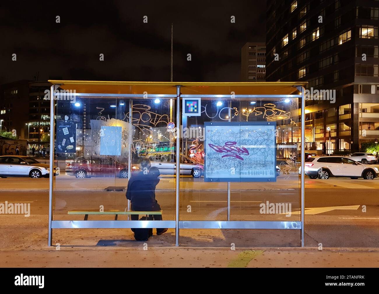 L'uomo sta aspettando in una stazione degli autobus di notte. Barcellona, Catalogna, Spagna. Foto Stock