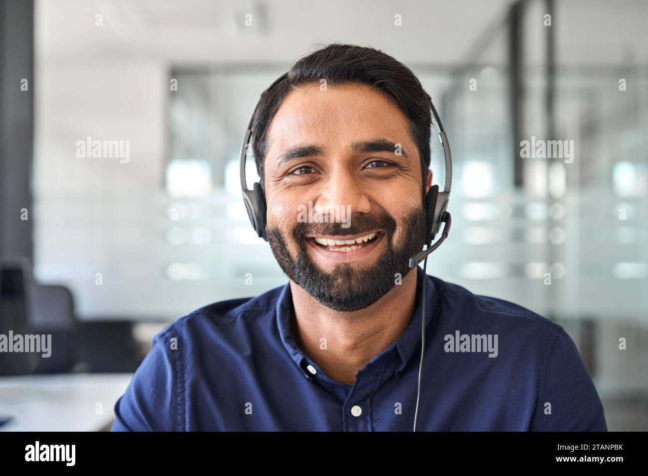 Agente di call center Happy Indian che indossa cuffie in ufficio. Ritratto. Foto Stock