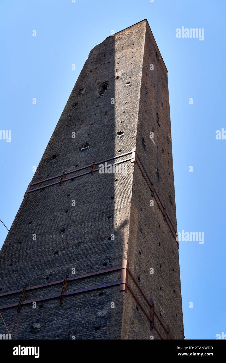 La Torre Garisenda una delle due torri pendenti di Bologna, le cinghie metalliche la aiutano a mantenere l'integrità strutturale Foto Stock