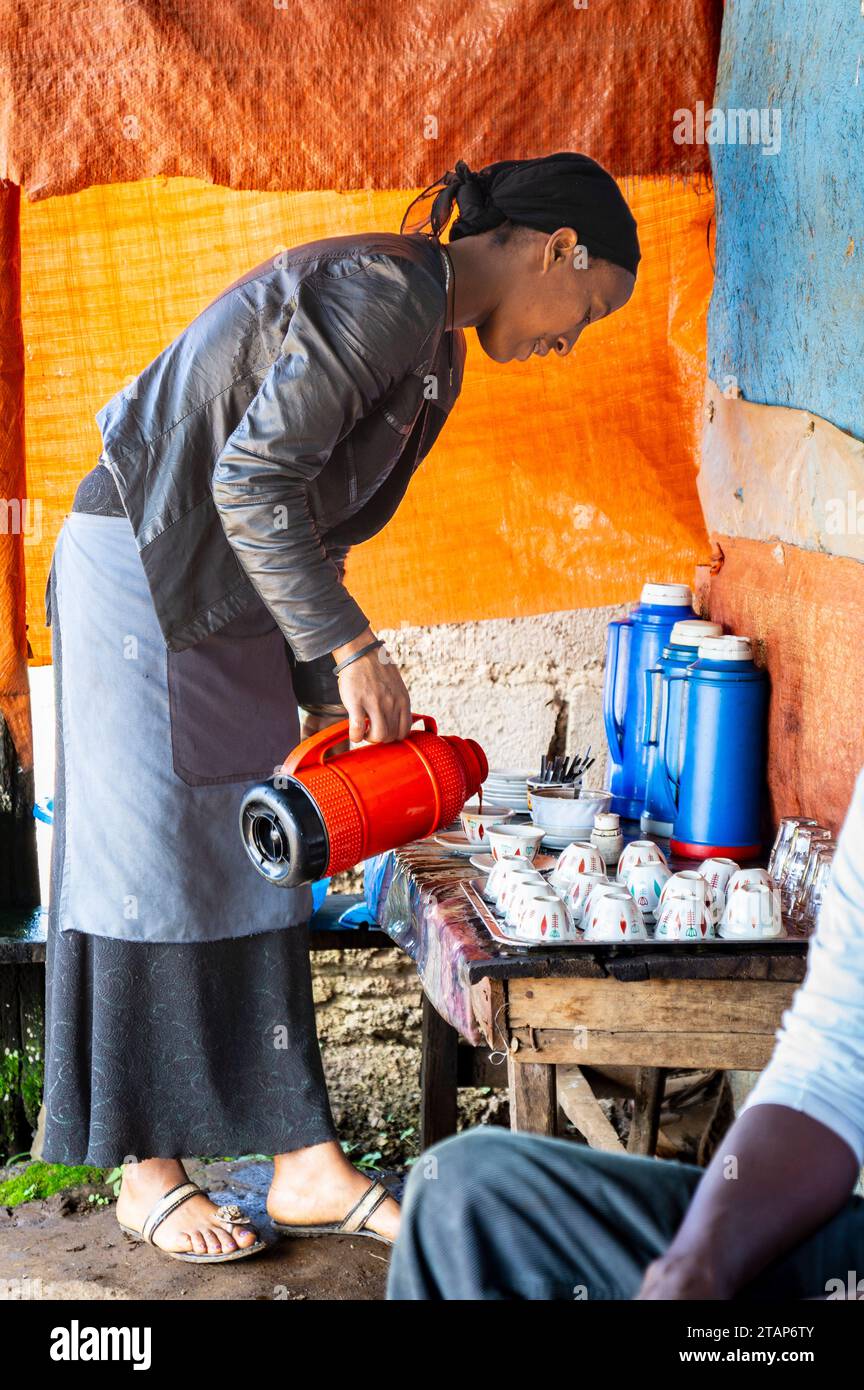 Una donna etiope versa caffè in un bar sulla strada Foto Stock