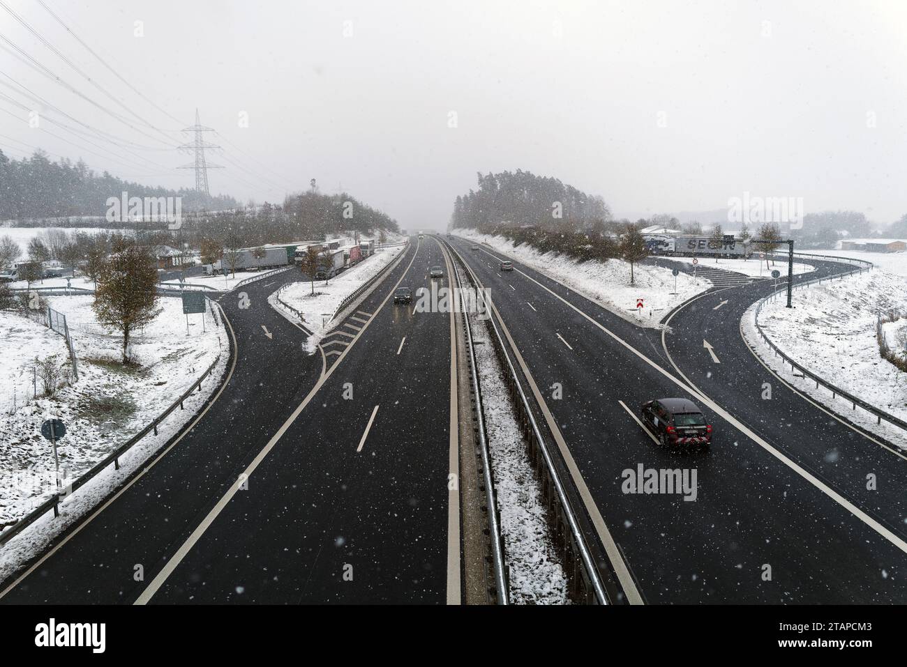 Coburg, Germania. 2 dicembre 2023. Clima freddo nel nord della Baviera dopo le forti nevicate, quando le auto passano sotto un ponte pedonale e gli autocarri fanno una pausa dalle difficili condizioni di guida. Credito: Clearpiximages/Alamy Live News Foto Stock