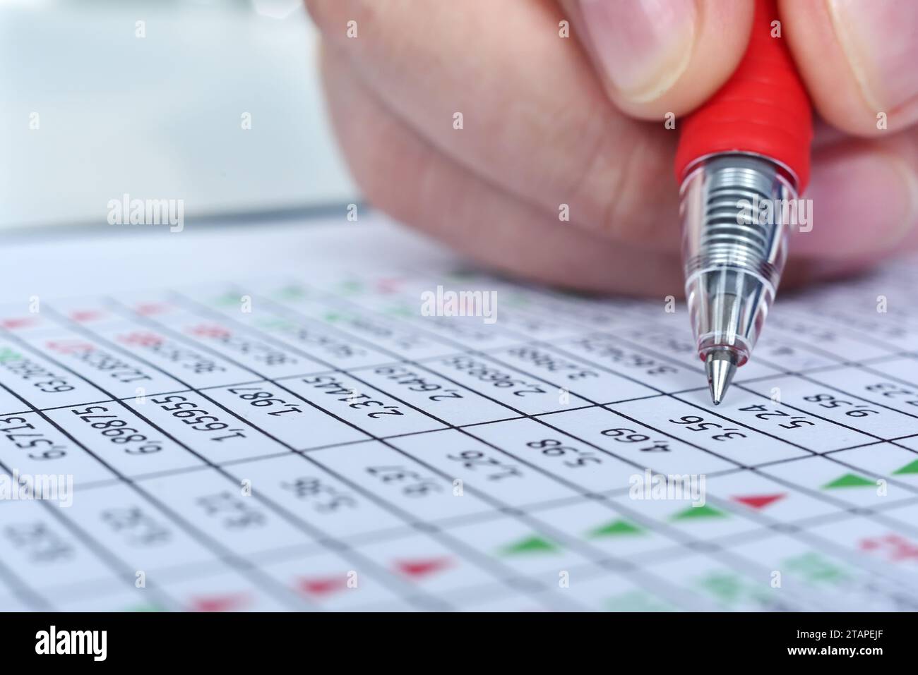 Trader man hand with pen correction Financial market report con i dati sulle azioni. Concetto di analisi finanziaria. Primo piano Foto Stock