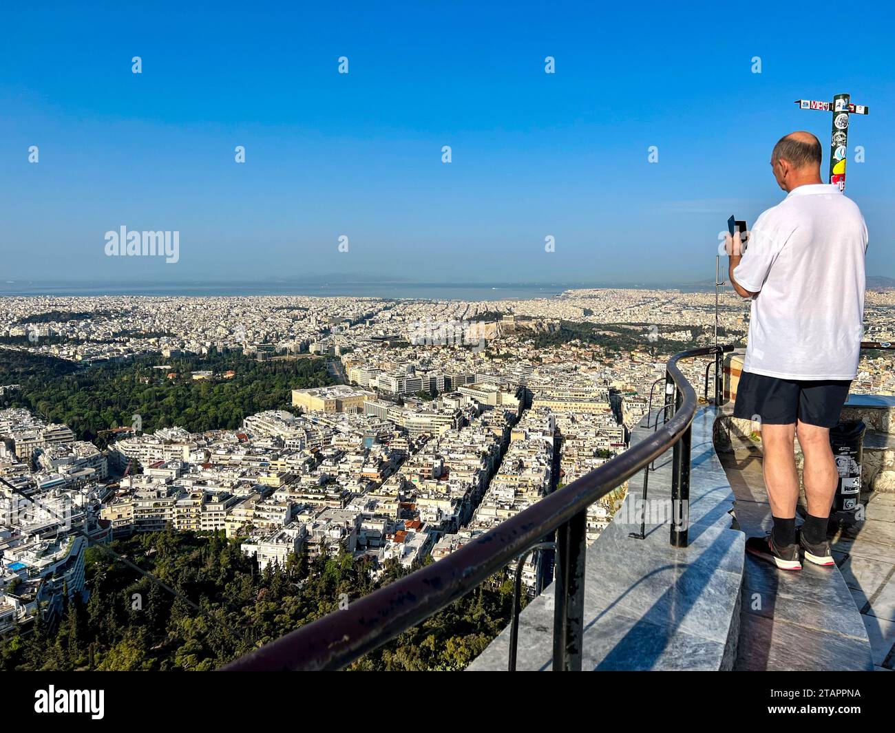 Vista posteriore di un uomo che scatta una foto dal belvedere sul monte Lycabettus, Atene, Attica, Grecia Foto Stock