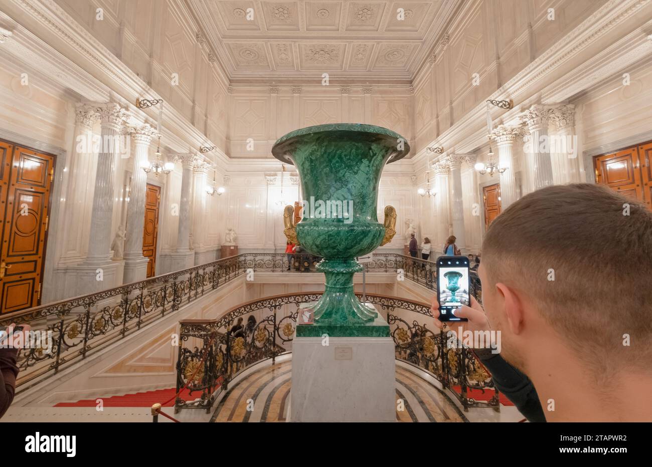Turista che scatta una foto dei grandi luoghi dei vasi di malachite presso la scalinata sovietica nel museo del grande Ermitage, palazzo d'inverno. St Pietroburgo, Russia Foto Stock