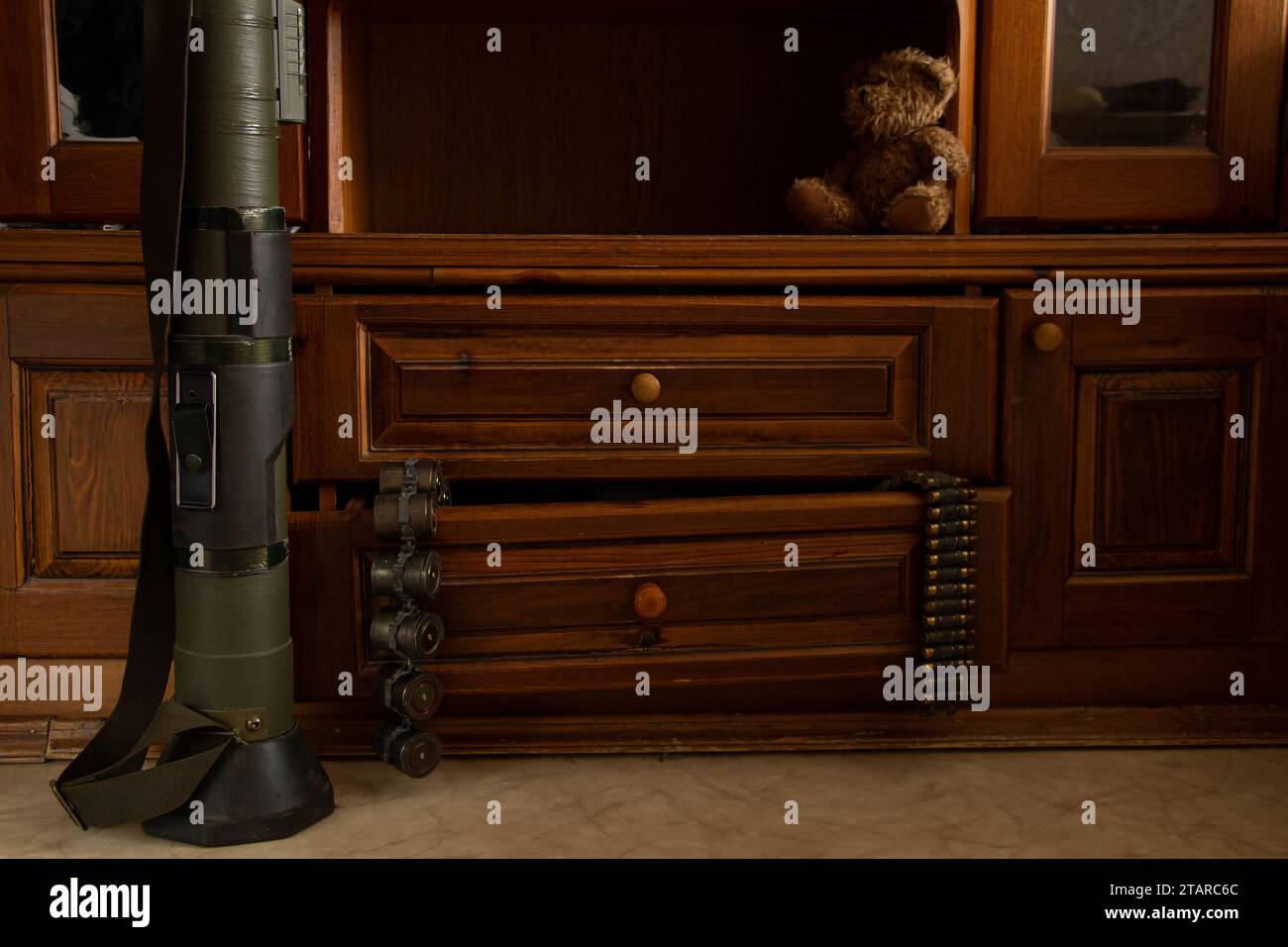 Un lanciagranate si trova sul pavimento, e le cinture di mitragliatrici con le cartucce sono appese a una scatola in un appartamento in Ucraina, le armi sono conservate in una casa Foto Stock