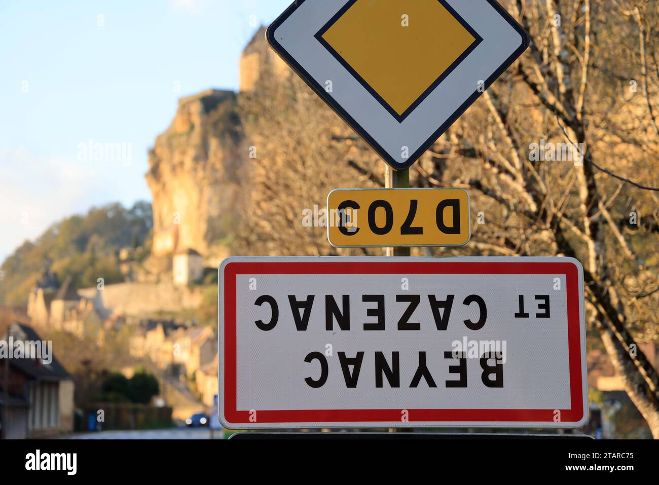 Beynac-et-Cazenac, Francia. 2 dicembre 2023. L'operazione dell'unione nazionale condotta dai sindacati agricoli ha chiamato "camminiamo sulla testa" per manifestare contro la politica agricola del governo. Questi agricoltori attivisti capovolgono i segnali che indicano i nomi delle aree urbane per denunciare oneri eccessivamente pesanti, importazioni di prodotti che indeboliscono notevolmente i redditi e concorrenza definita sleale rispetto a norme europee sempre più restrittive. In questa foto è il segno del villaggio rurale e turistico di Beynac-et-Cazenac in Dordogna, nel sud-ovest della Francia, che ha appena b Foto Stock