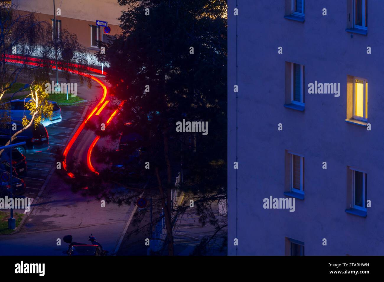 Vienna: Finestra illuminata in casa di notte, luce posteriore traccia di lasciare l'auto in 22. Donaustadt, Vienna, Austria Foto Stock