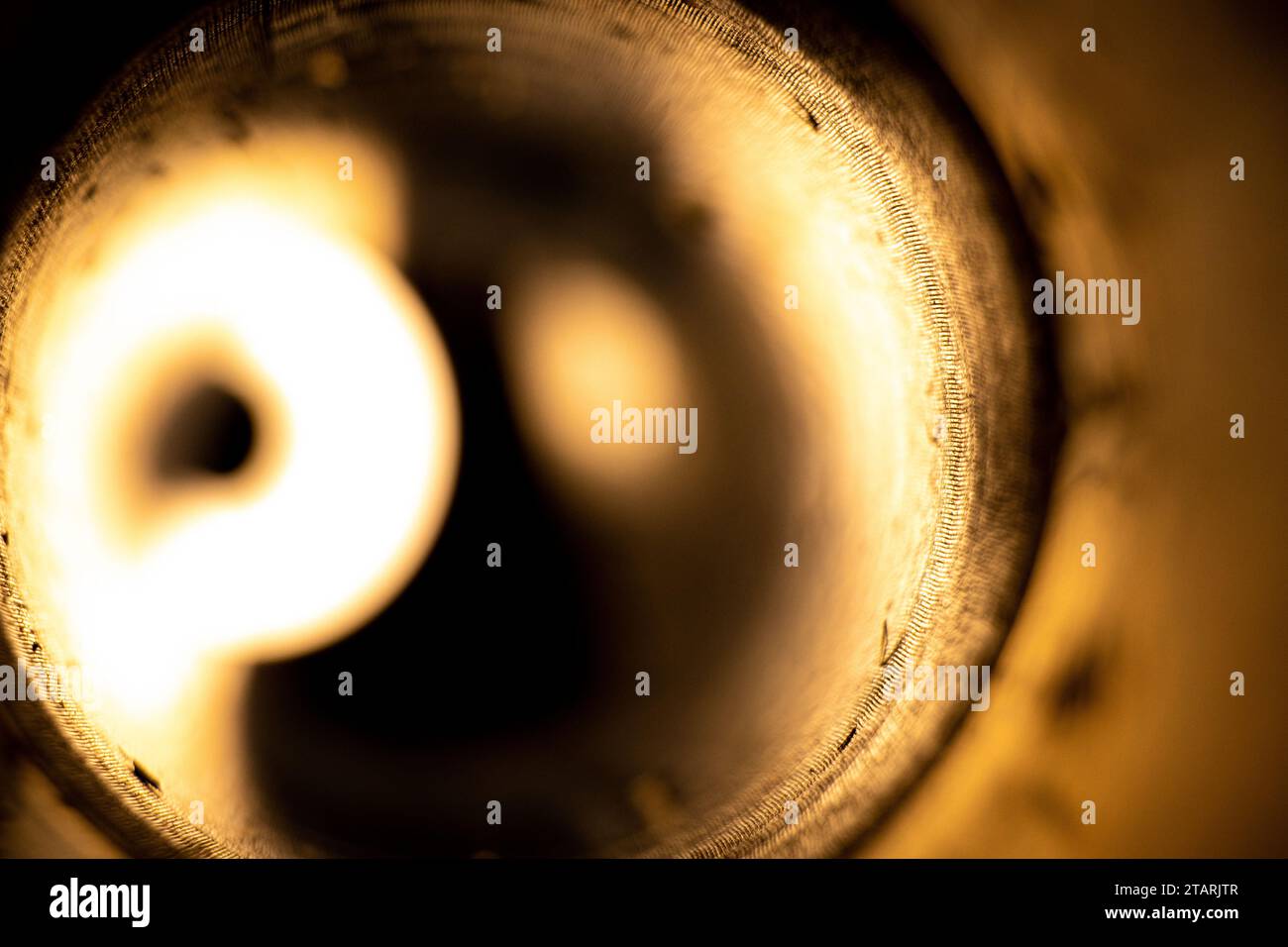 Torcia elettrica in un lanciagranate anticarro vuoto usato come sfondo, luce brillante in un cerchio, luce da un buco Foto Stock