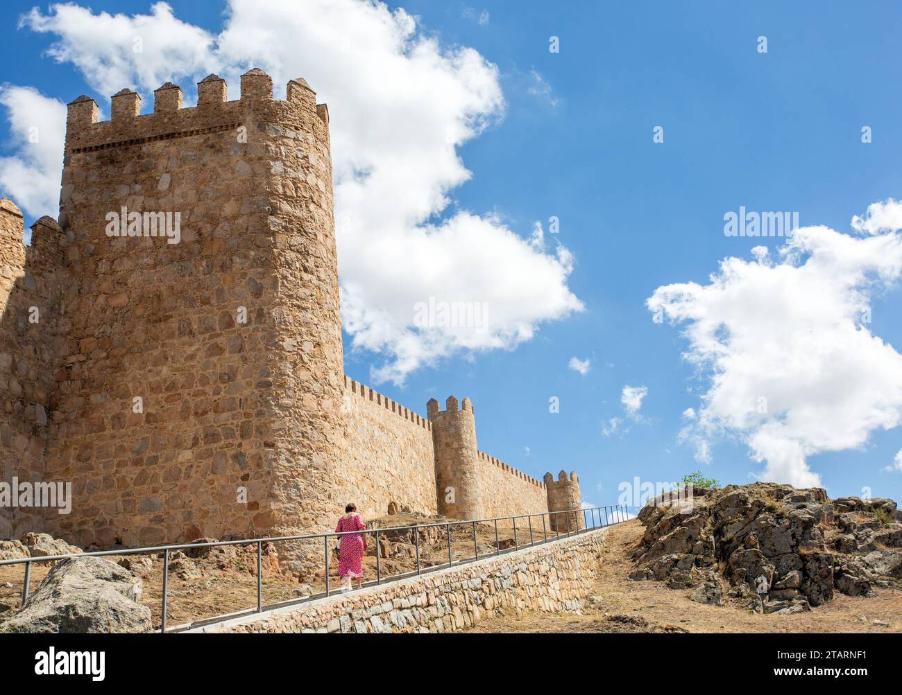Donna che cammina lungo i bastioni nella città medievale fortificata spagnola di Aliva capitale della provincia spagnola di Avila in Castiglia e León in Spagna Foto Stock