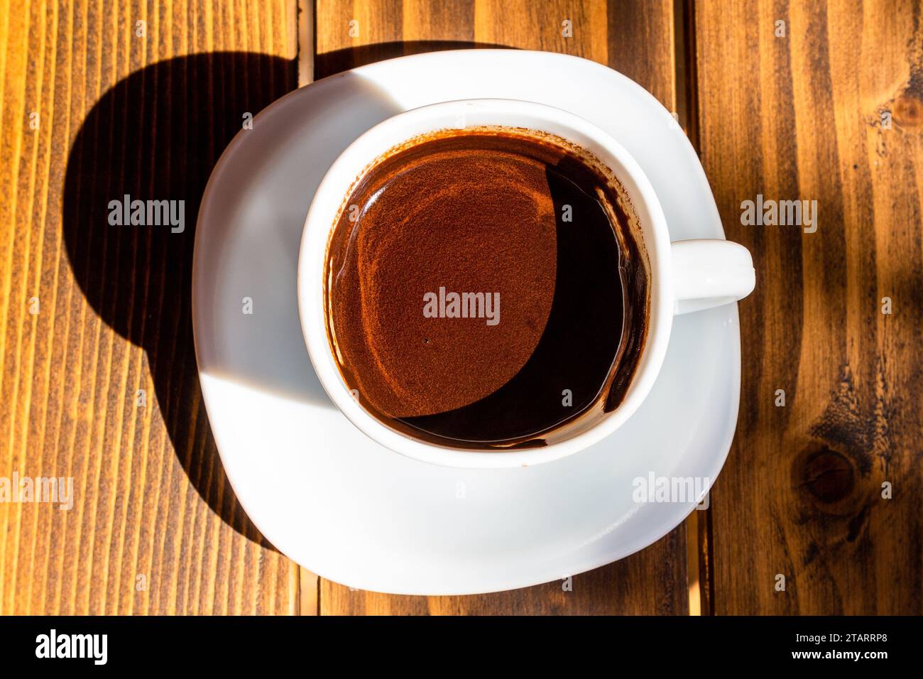 Viaggio in Georgia - vista dall'alto di una tazza di caffè turco illuminata dal sole su un tavolo di legno nella caffetteria all'aperto della città di Batumi nel soleggiato giorno autunnale Foto Stock