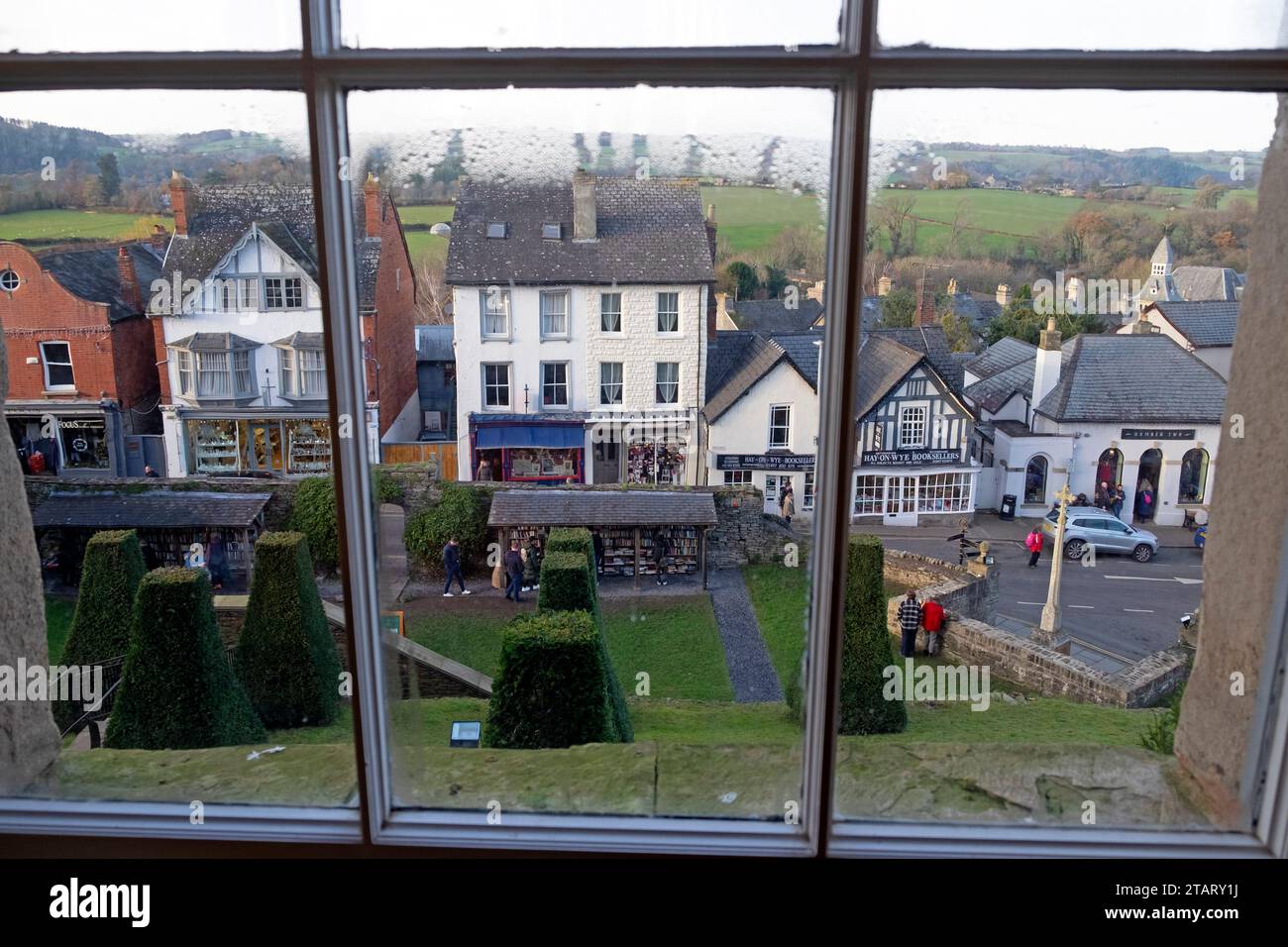 Vista dei negozi della città del libro e della strada all'esterno dall'interno del castello di Hay guardando attraverso la finestra Hay-on-Wye Galles Regno Unito Gran Bretagna KATHY DEWITT Foto Stock