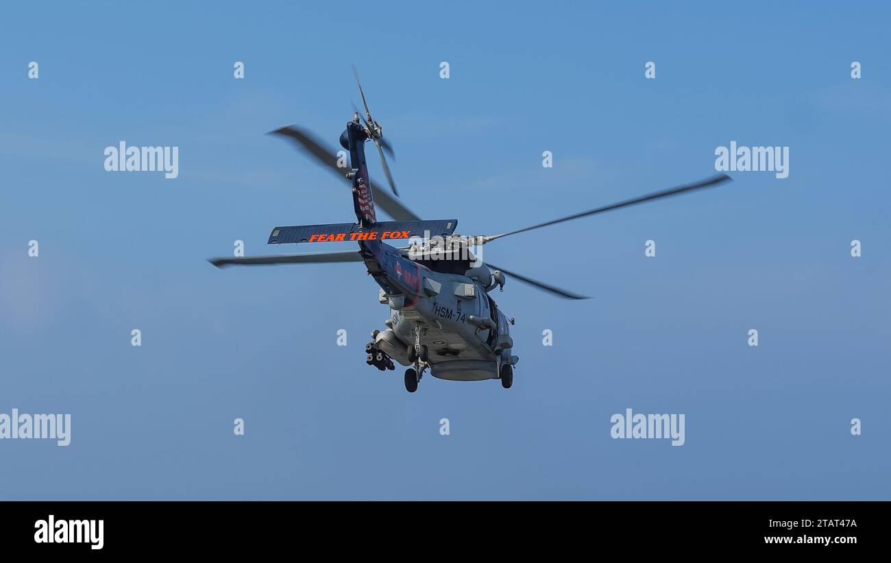 IMBOSCATA 700, un elicottero MH-60R Sea Hawk e lo squadrone “show bird” attaccato alle “Swamp Foxes” dell’Helicopter Maritime Strike Squadron (HSM) 74 conducono un volo durante una cerimonia di cambio di comando a bordo della portaerei USS Dwight D. Eisenhower (CVN 69) nel Golfo dell’Oman 17 novembre, 2023. Come parte del Dwight D. Eisenhower Carrier Strike Group (IKECSG), HSM 74 nell'area operativa della 5th Fleet degli Stati Uniti per sostenere la sicurezza marittima e la stabilità in Medio Oriente. (Foto della Marina degli Stati Uniti di Naval Air Crewman 2nd Class Kenny Pogoy) Foto Stock