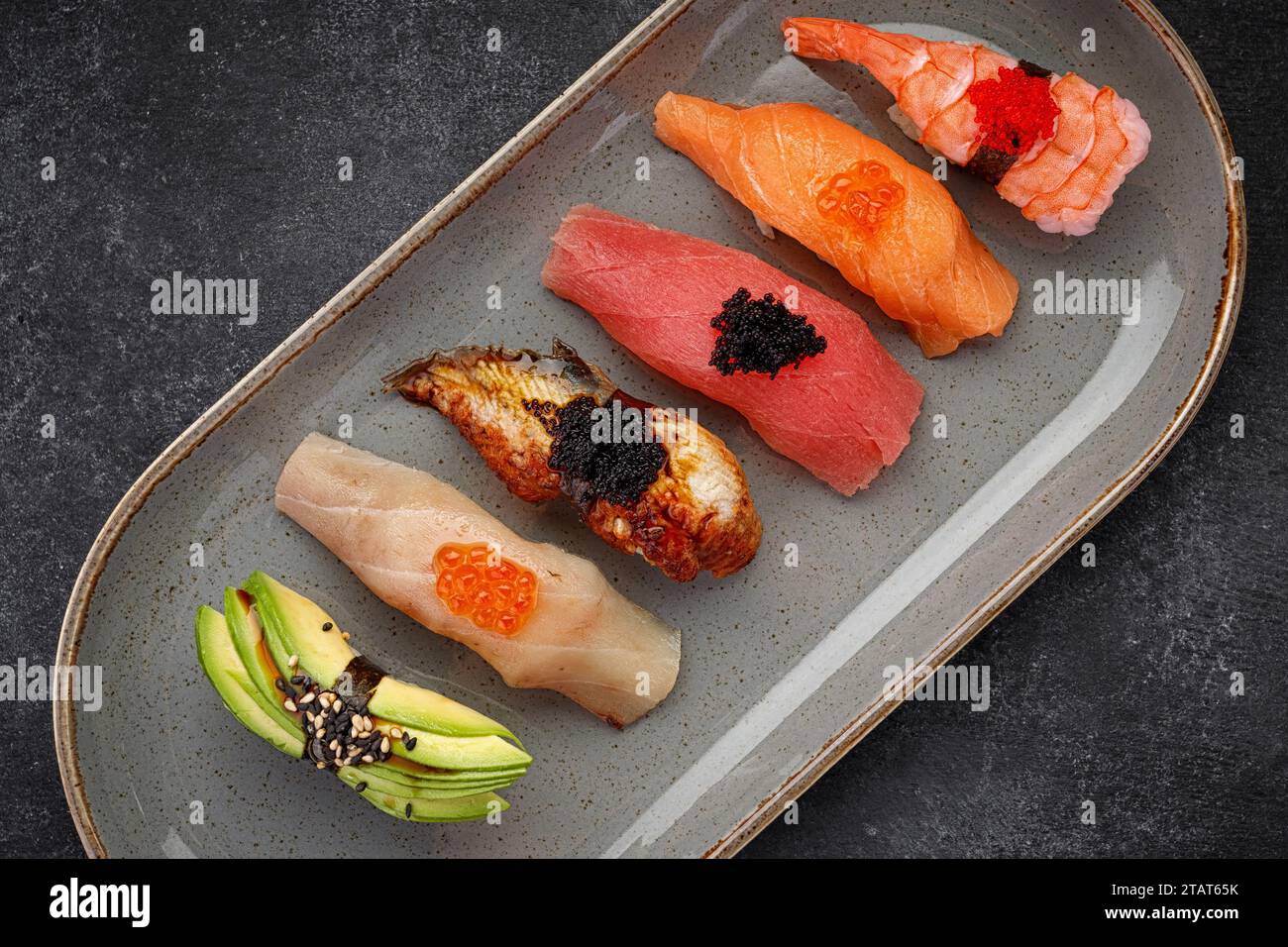 Sushi Nigiri assortito su un piatto, su cemento scuro Foto Stock