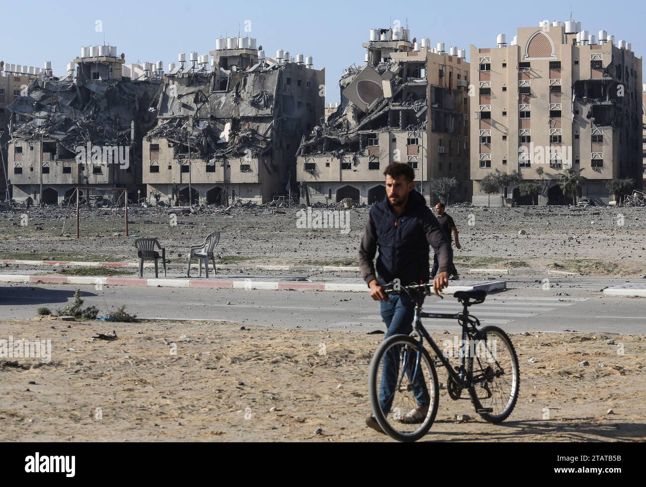 Gaza, Palestina. 2 dicembre 2023. Un uomo palestinese spinge la sua bicicletta mentre fugge dalla sua casa dopo che uno sciopero israeliano ha colpito 7 torri nella città di Hamad. Una tregua temporanea tra Israele e Hamas è scaduta il 1° dicembre, con l'esercito israeliano che ha affermato che le operazioni di combattimento erano riprese, accusando Hamas di aver violato la pausa operativa. Credito: SOPA Images Limited/Alamy Live News Foto Stock