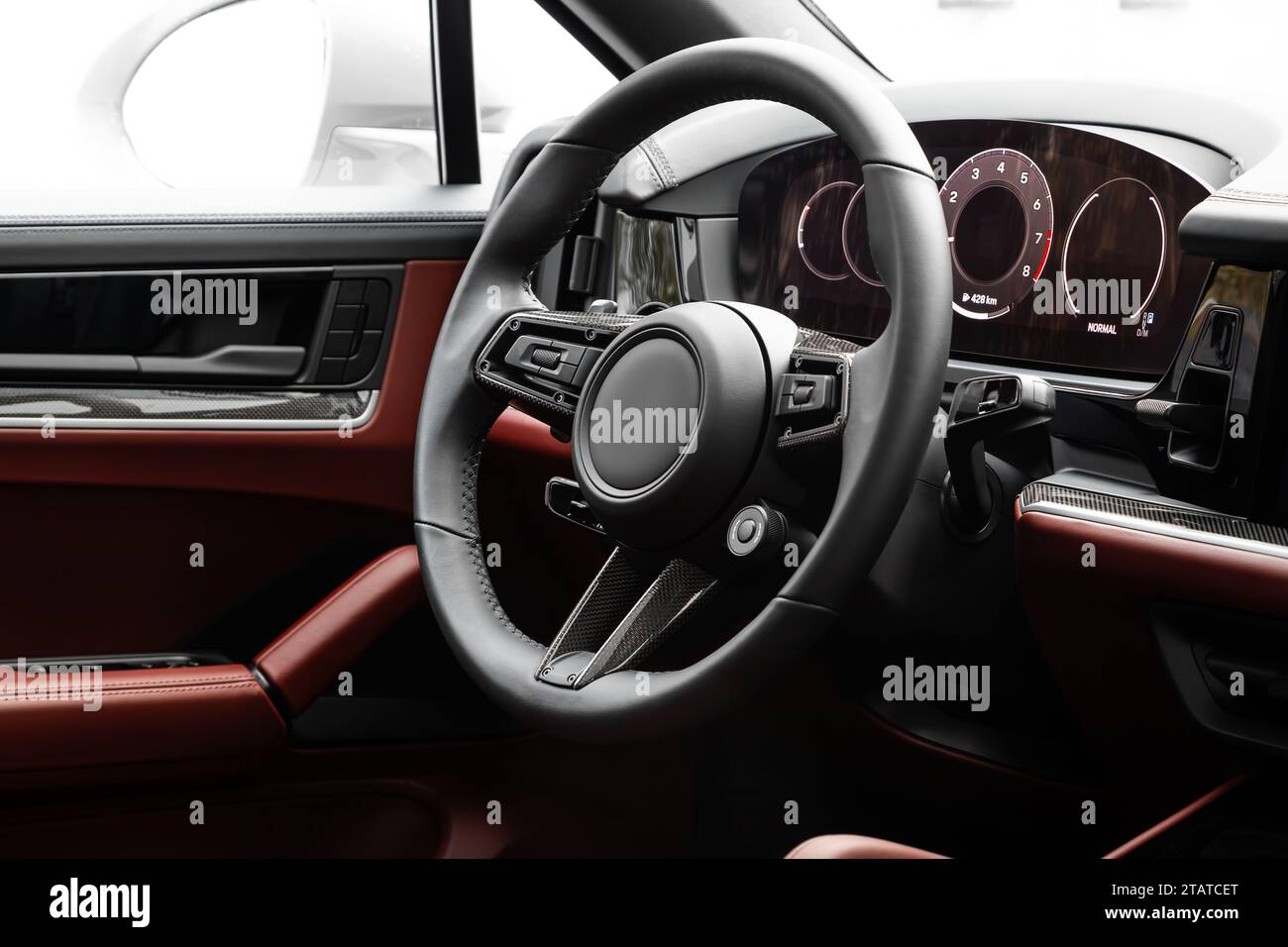 Interni di una nuova e moderna SUV con volante, leva del cambio e cruscotto, climatizzatore, tachimetro, display. Interni in pelle rossa Foto Stock
