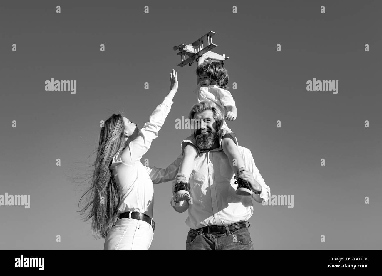 Figlio con padre e madre. Mamma, papà e bambino ragazzo con aereo giocattolo, vacanza e convivenza. Giorno bambini. Bambino che gioca con l'aeroplano giocattolo e. Foto Stock