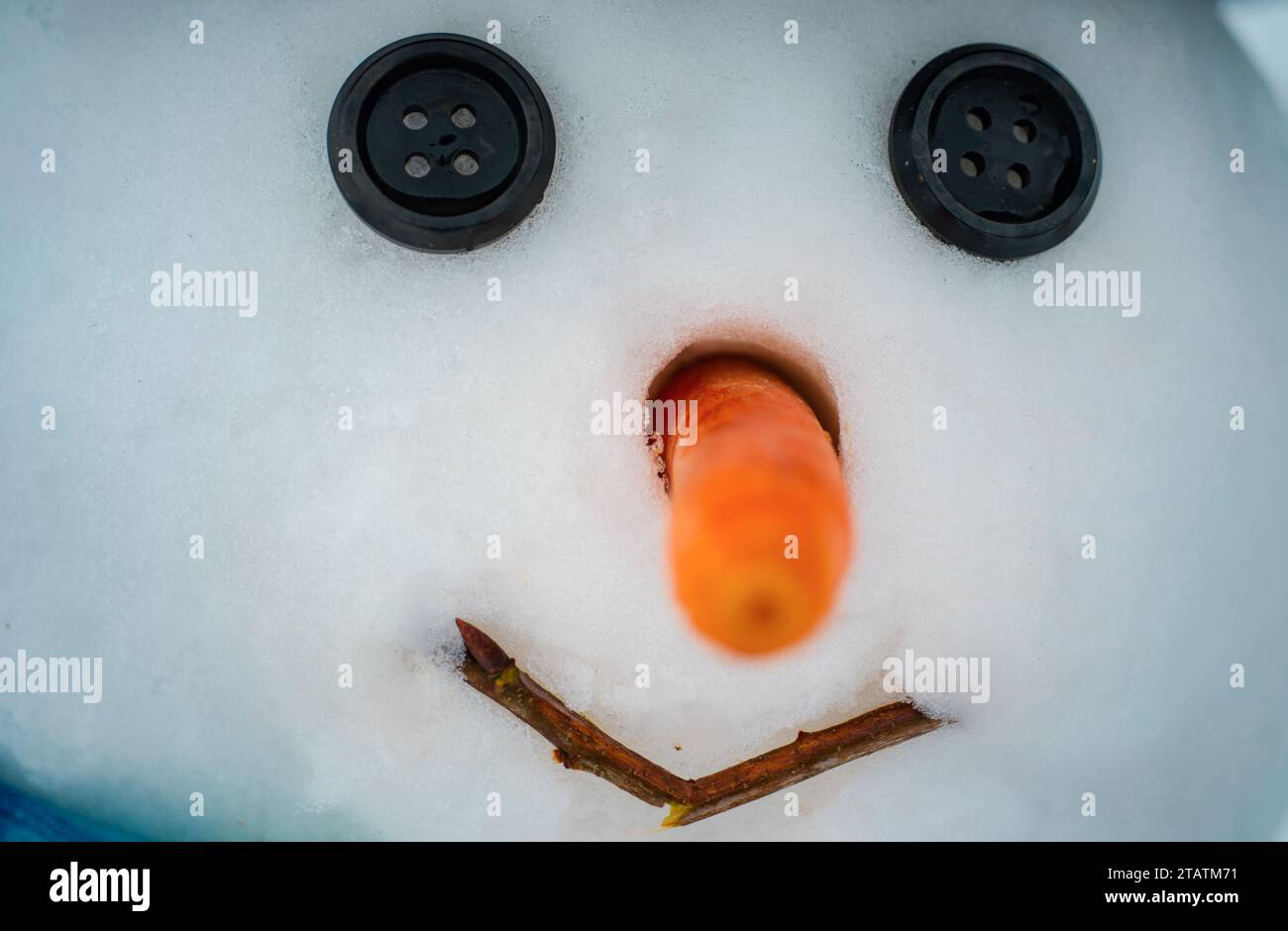 Buon pupazzo di neve divertente nella neve. Concetto di Natale per Capodanno. Pupazzo di neve con naso rosso e pulsante occhi neri. Foto Stock