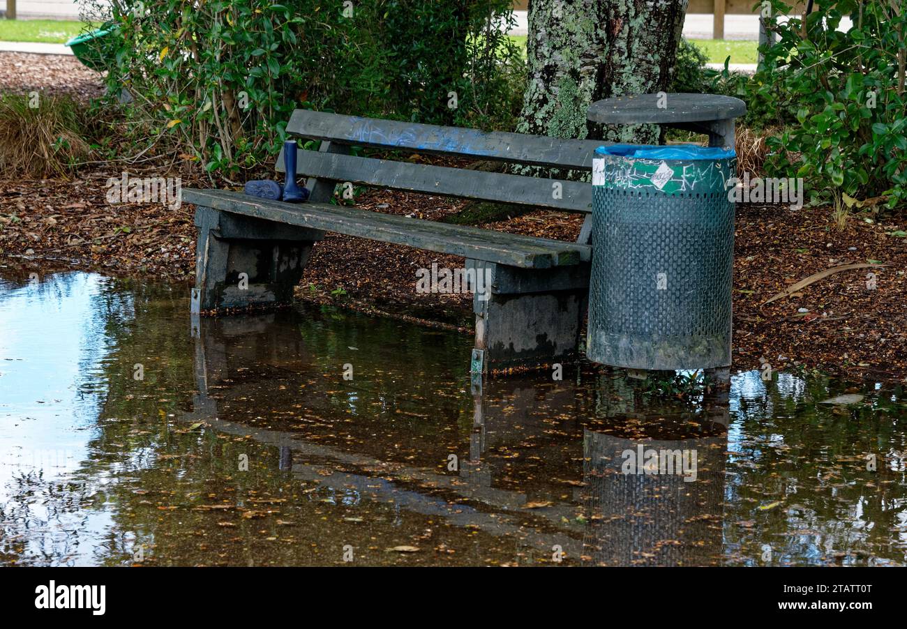 La forte pioggia ha causato la fuoriuscita di acqua intorno a un sedile e a un cestino dei rifiuti Foto Stock