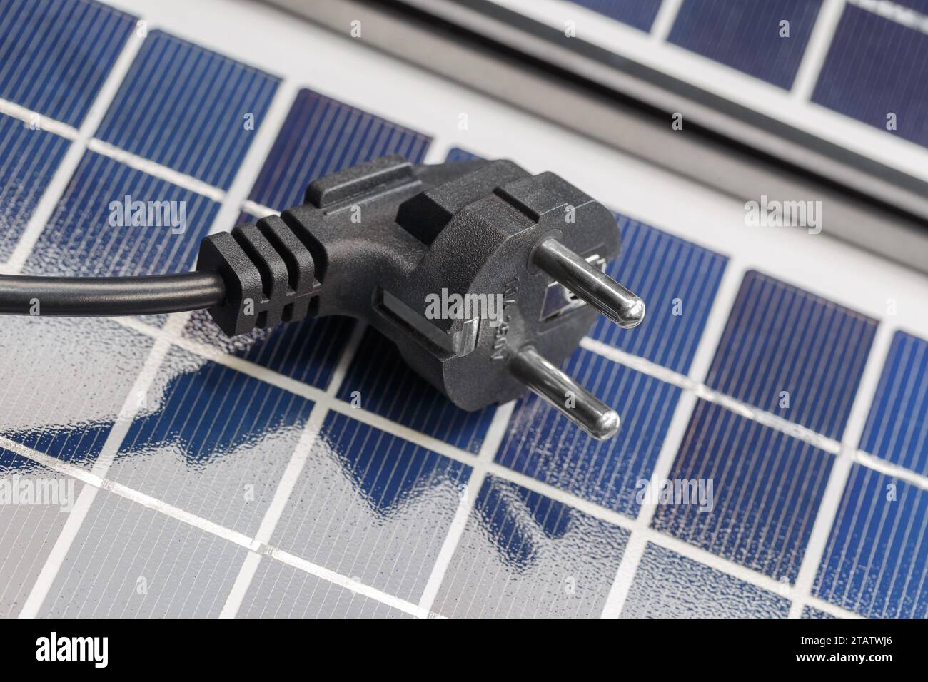 Una spina elettrica si trova sui pannelli solari. Il concetto di energia solare rispettosa dell'ambiente. Foto Stock